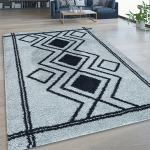 Geometric patterned rug on a wooden floor with a living room in the background
