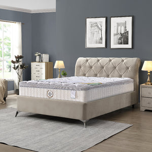 Beige upholstered bed with tufted headboard in a bedroom setting.