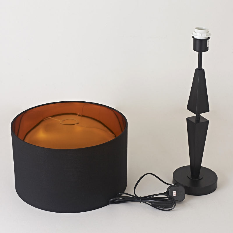 Black lamp with gold interior shade and black base on a white background