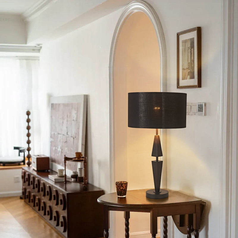 Decorative lamp on a wooden table in a room with a mirror and framed picture.