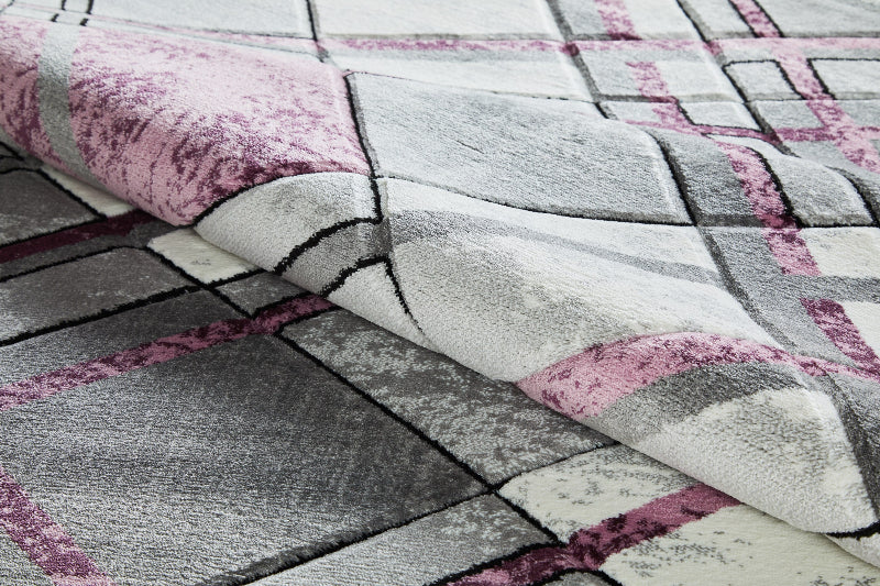 Accra Rug Close-up of a patterned rug with pink, gray, and white colors.