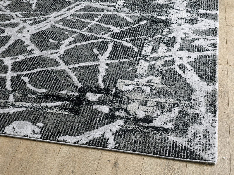 Gray and white geometric patterned rug on a wooden floor