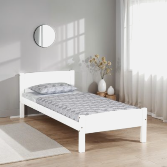 White bed frame with gray mattress in a minimalistic bedroom.
