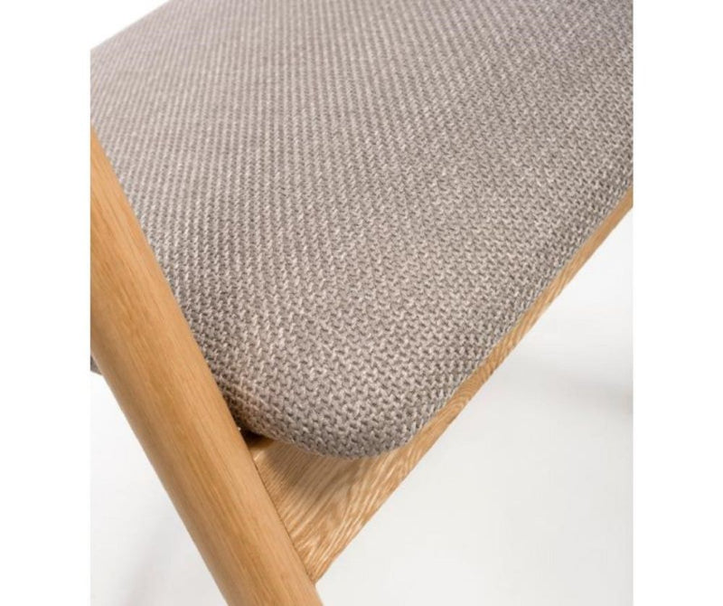 A Anders Oak Dining Chair with a beige upholstered seat and a wooden frame.