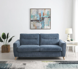 Blue sofa in a living room with a abstract painting on the wall.