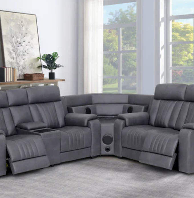 Gray sectional sofa in a living room with large windows.