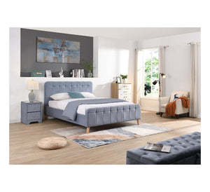 Modern bedroom with a sky blue upholstered bed, nightstands, and a chair.
