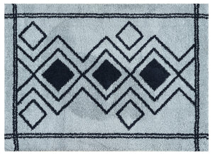 Geometric patterned rug with black diamonds on a light blue background