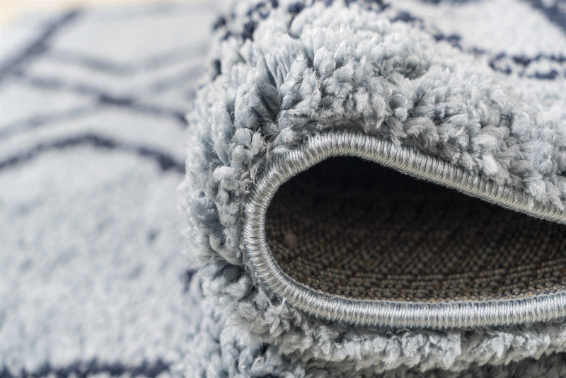 Close-up of a textured blue and white rug corner