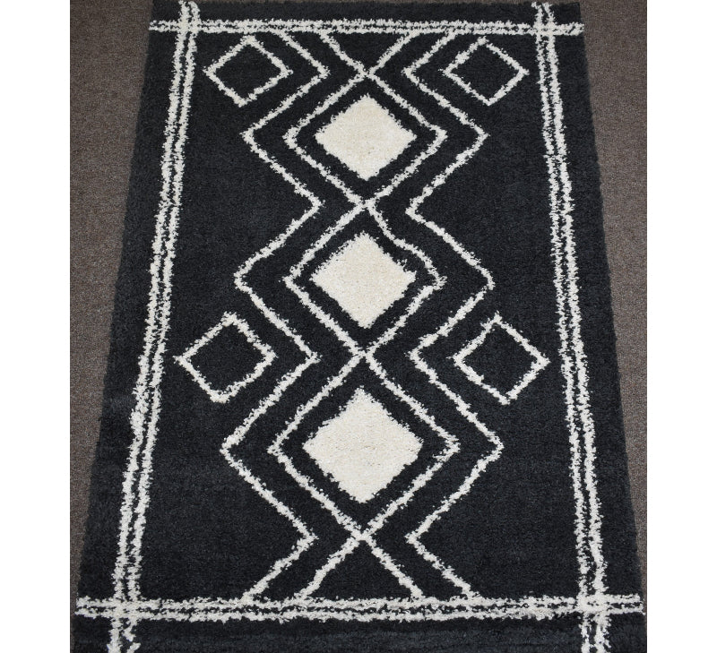 Black rug with white geometric pattern on a plain background