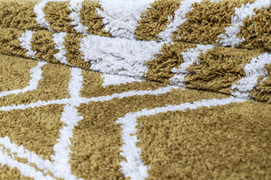 Close-up of a textured gold and white rug with geometric pattern