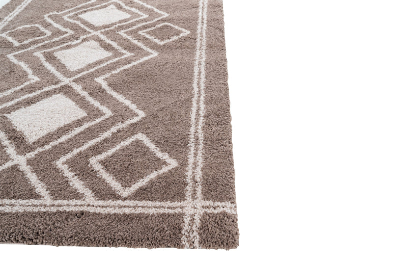 Close-up of a brown and white geometric patterned rug on a plain background