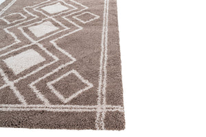 Close-up of a brown and white geometric patterned rug on a plain background