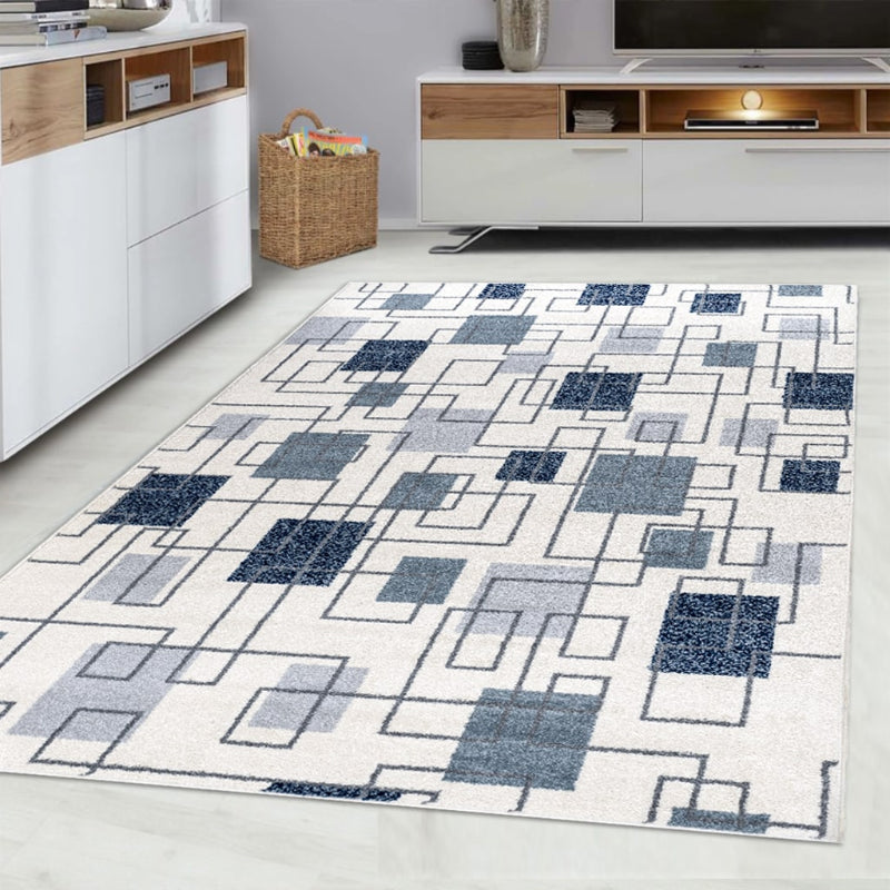 Geometric patterned rug on a light wood floor with white walls and furniture.