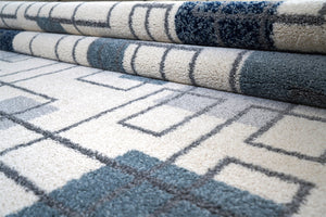 Three rolls of patterned carpet with geometric designs on a neutral background
