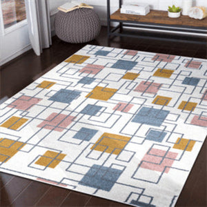 Geometric patterned rug on a wooden floor with a side table and plant in the background.
