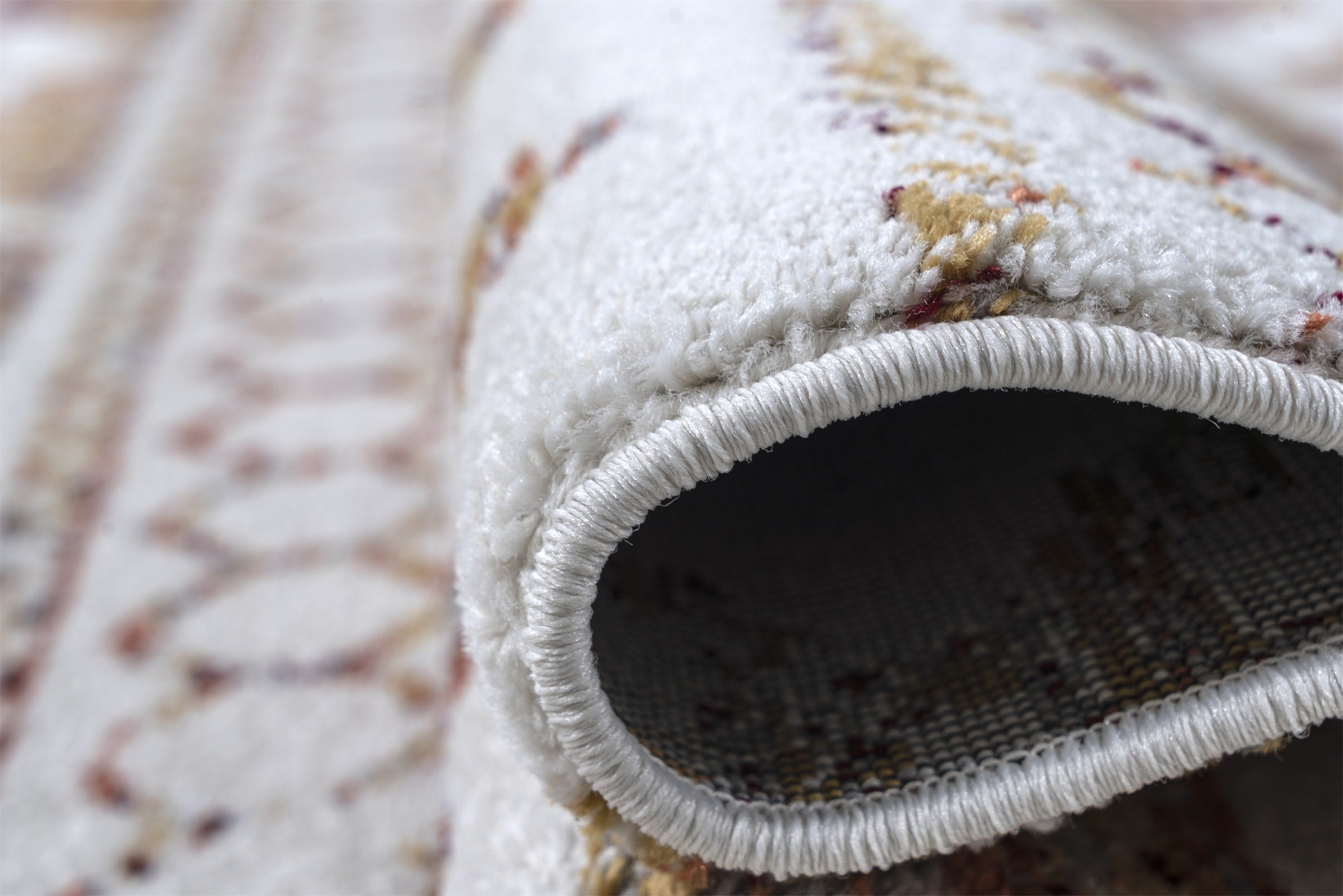 Close-up of a textured rug with a focus on the border and pile.