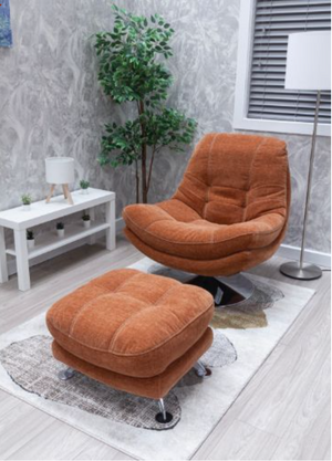 Orange chair and ottoman set in a room with a plant and small table.