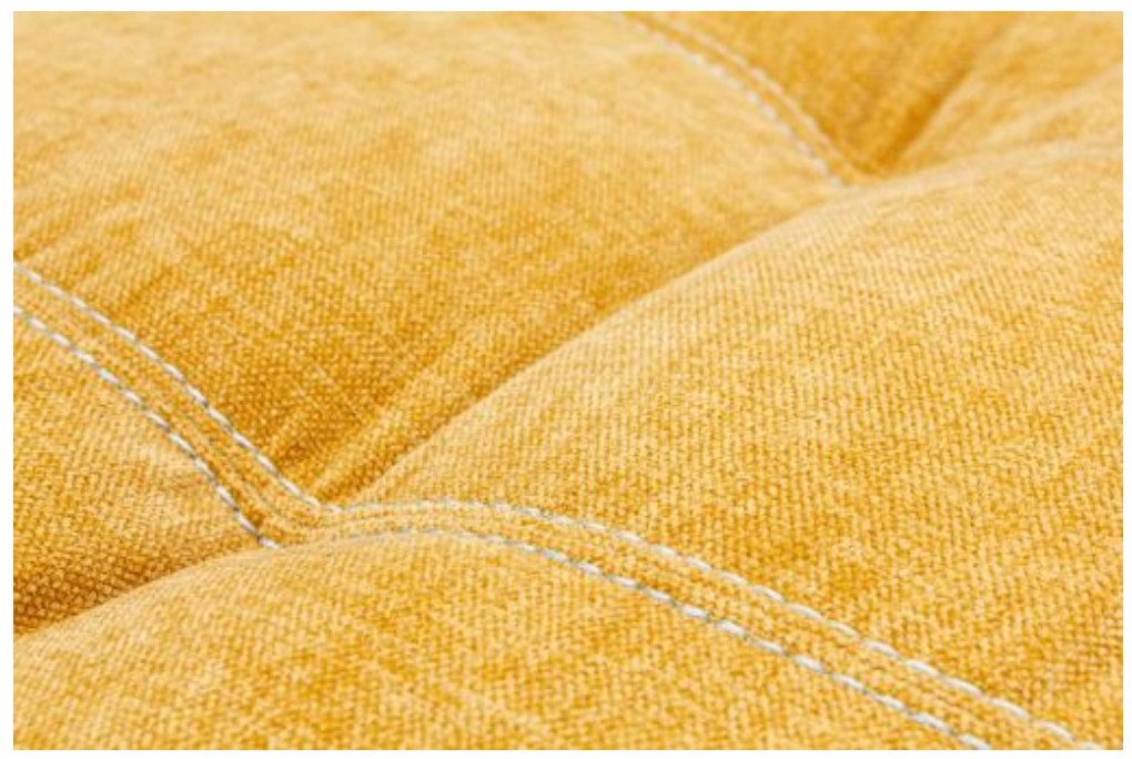 Close-up of a yellow quilted fabric with visible stitching