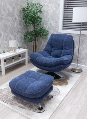 Blue recliner chair with ottoman in a room with a plant and white table.