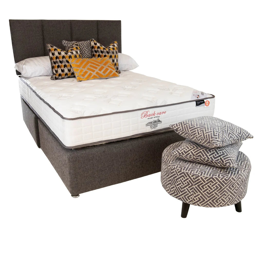 A gray, pocket spring mattress with a white label on the foot, presented in a bed frame, accompanied by a decorative cushion.