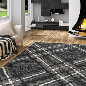 Living room with a black and white checkered rug, beige sofa, and fireplace.