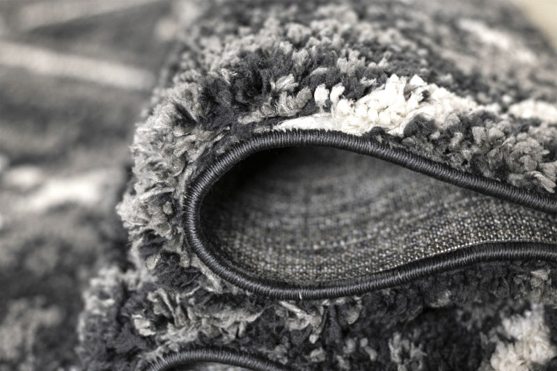 Close-up of a textured fabric with a zipper, likely from a jacket or coat, on a blurred background.