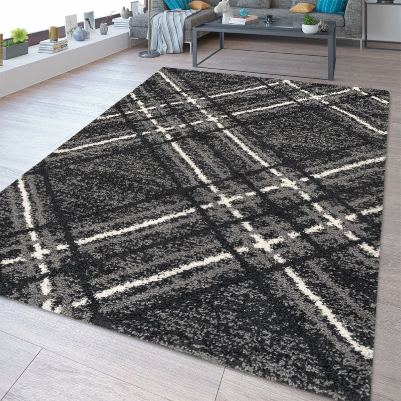 Plaid patterned rug on a wooden floor with a living room in the background