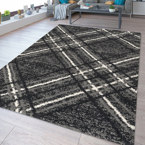 Plaid patterned rug on a wooden floor with a living room in the background