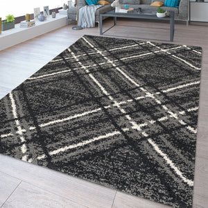 Plaid patterned rug on a wooden floor with a living room in the background