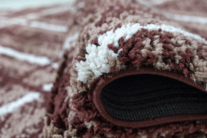 Close-up of a textured brown and beige rug with a folded edge.