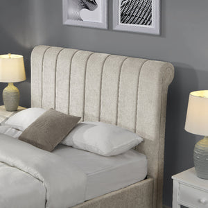 Beige upholstered headboard with pillows on a bed in a bedroom setting.