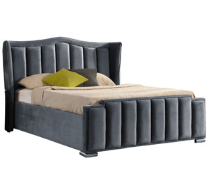 Gray upholstered bed with beige bedding and a green pillow on a white background