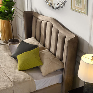 Mink upholstered headboard with decorative pillows in a bedroom setting.