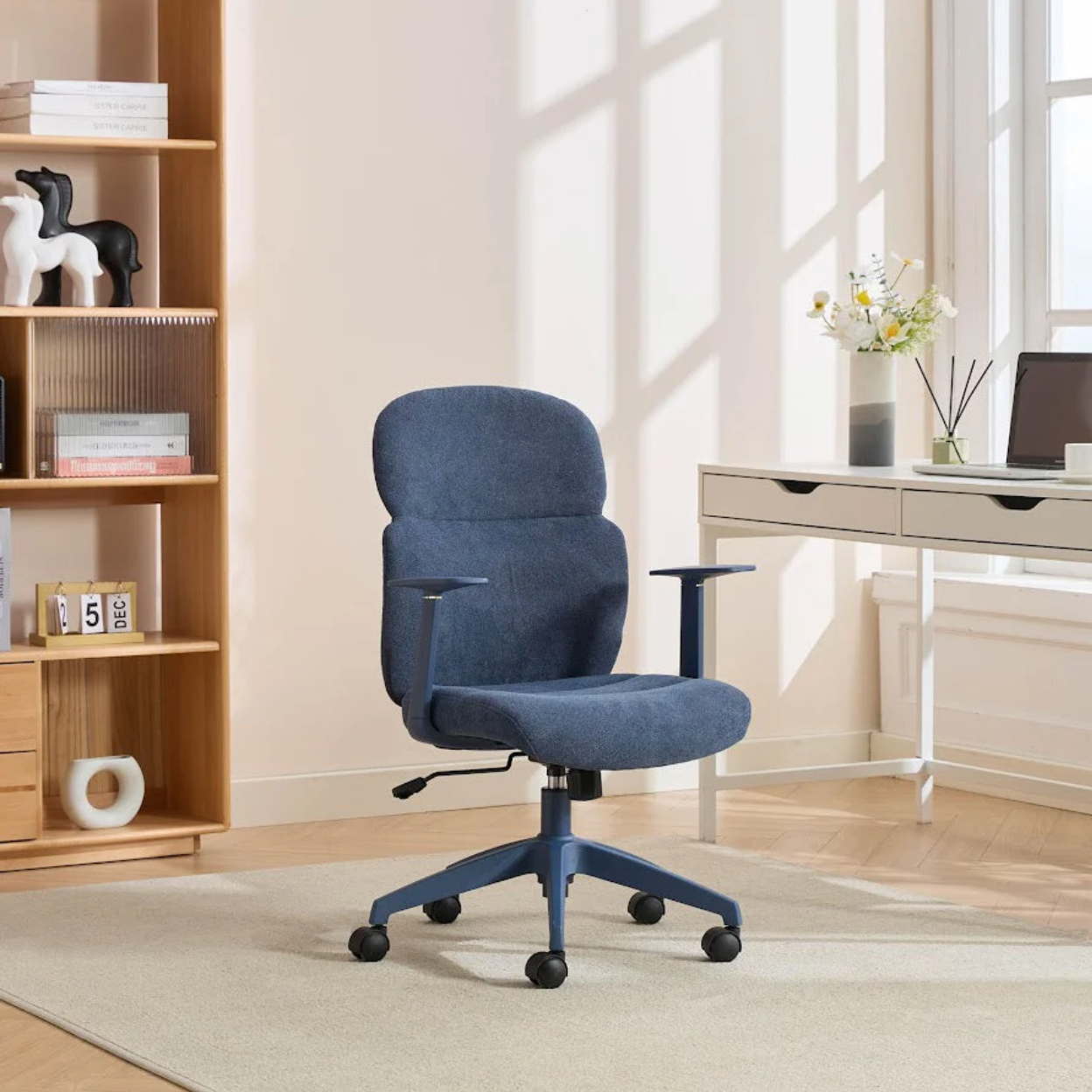 Blue office chair in a home office setting with a desk and shelves.