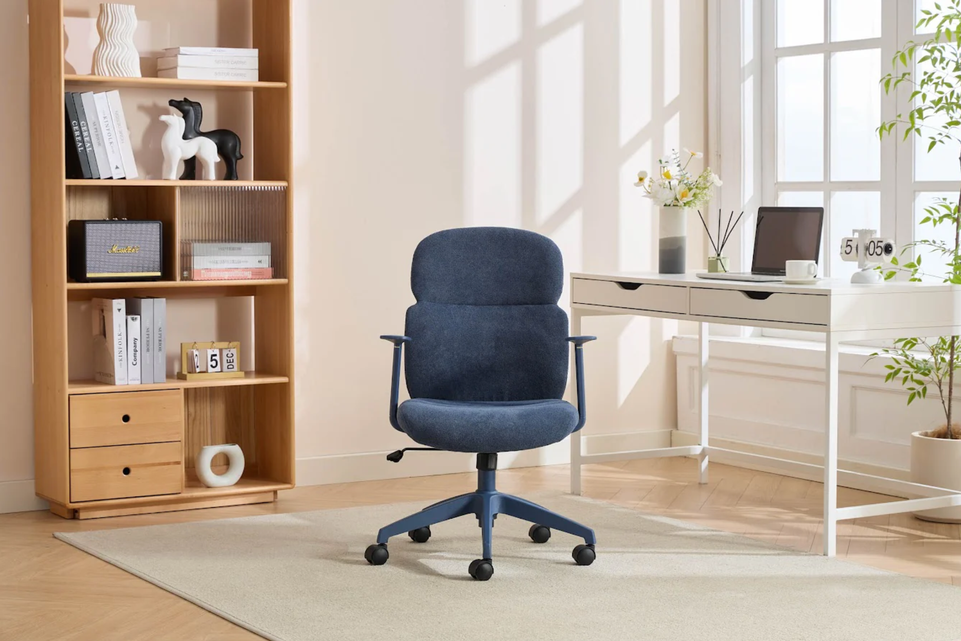 Blue office chair in a home office setting with a bookshelf and desk.