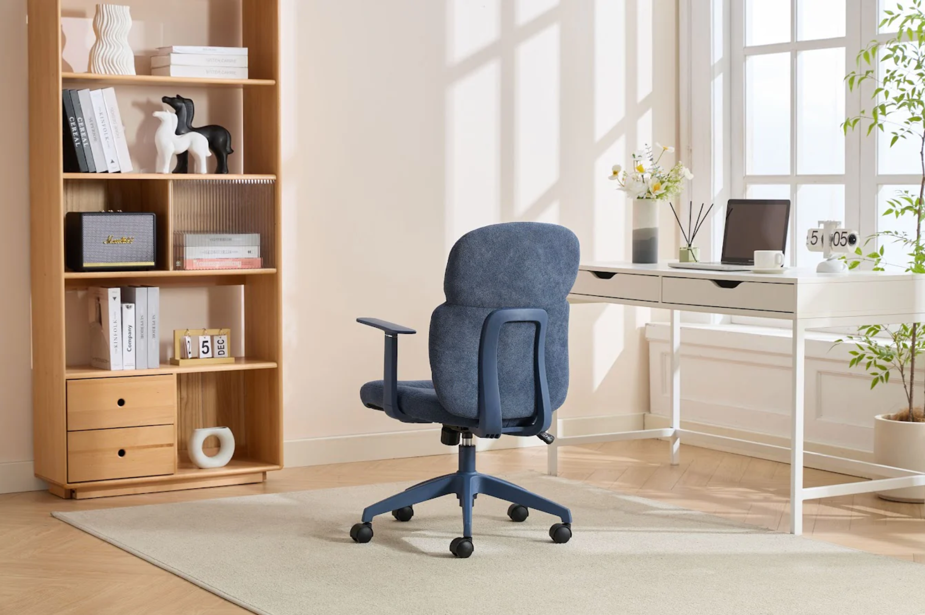 Blue office chair in a home office setting with a bookshelf and desk.