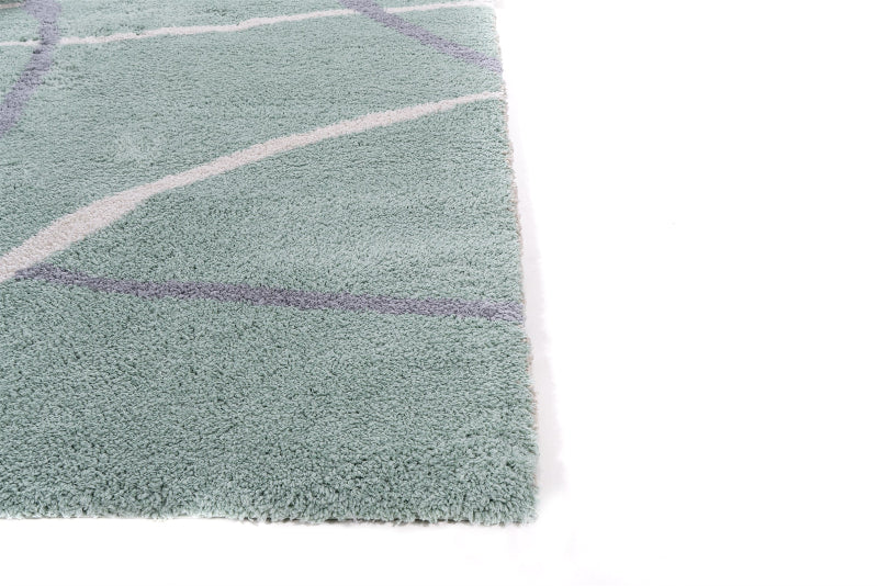 Green rug with purple and white geometric patterns on a white background