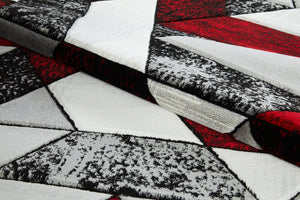Close-up of a geometric-patterned rug with black, white, and red colors.
