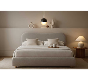 Neatly made bed with pillows in a bedroom setting with a lamp and decor items.