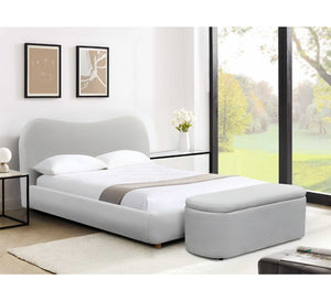 Modern bedroom with a gray upholstered bed and matching ottoman.