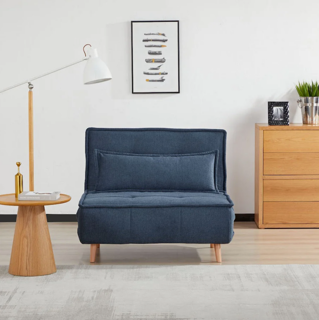 Blue sofa bed in a room with wooden furniture and decor