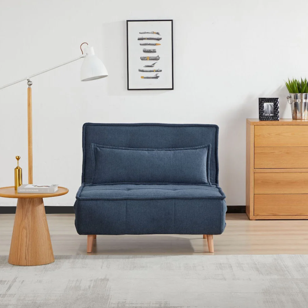 Blue sofa bed in a room with wooden furniture and decor