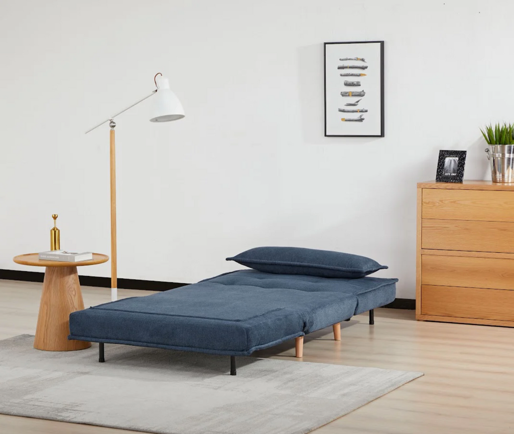 Blue sofa bed in a room with wooden furniture and decor