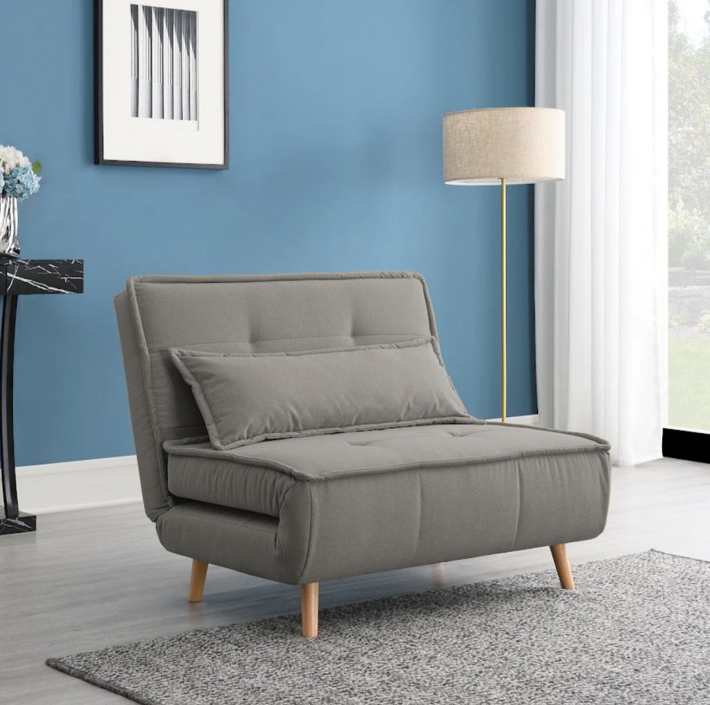 Grey sofa bed in a room with blue walls, a lamp, and a window.