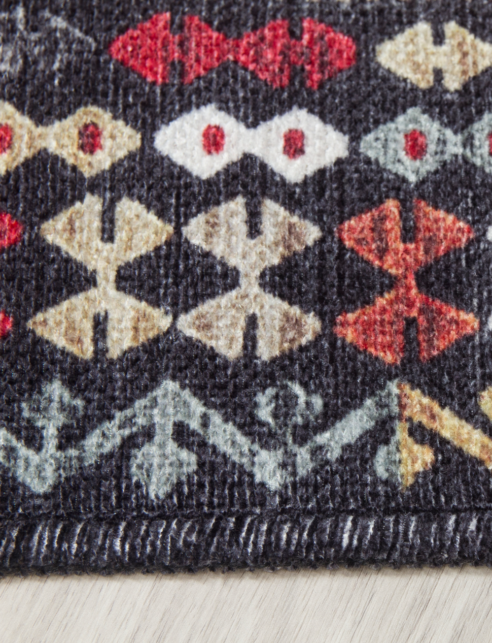 Close-up of a patterned rug with geometric shapes on a neutral background