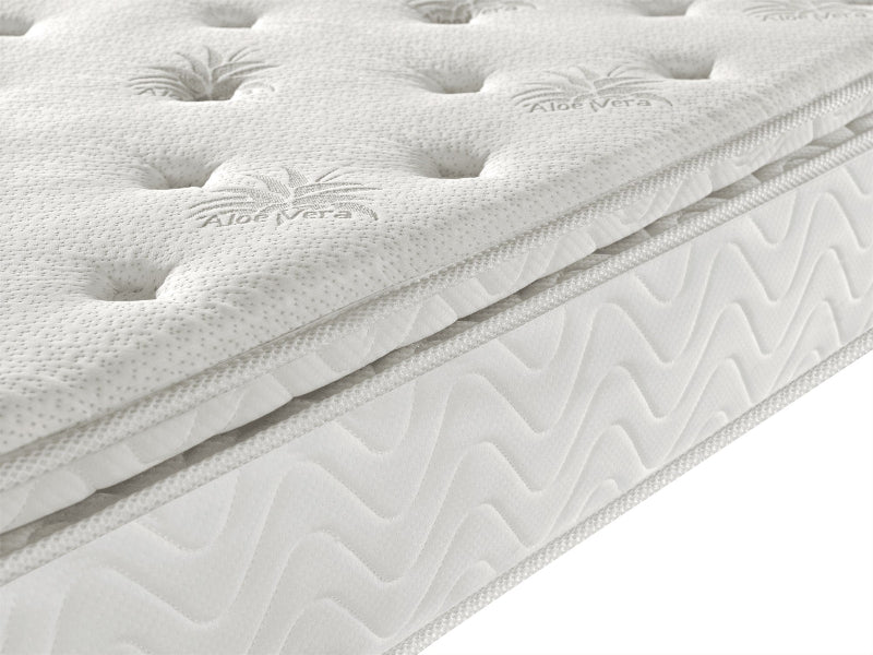 Close-up of a white mattress with 'Aloe Vera' branding on a white background