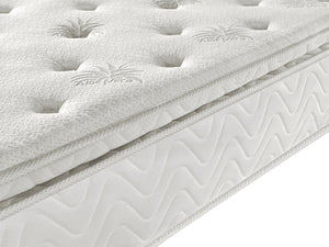Close-up of a white mattress with 'Aloe Vera' branding on a white background