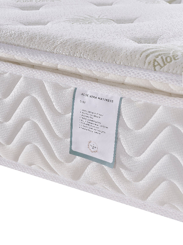 Close-up of a white mattress with 'Aloe' branding and product details label.