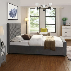 Modern bedroom with grey upholstered bed, wooden floor, and large windows.